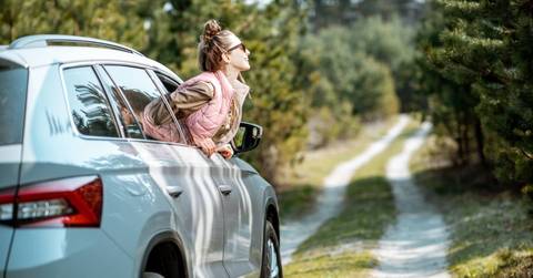 Looking out the car window on a picturesque road in the woods 