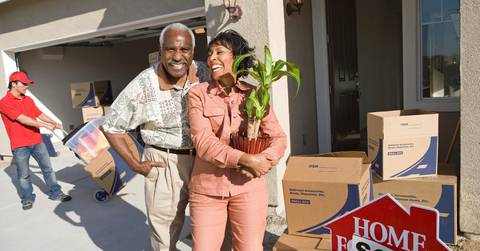 african american couple with belongings moving into a new house